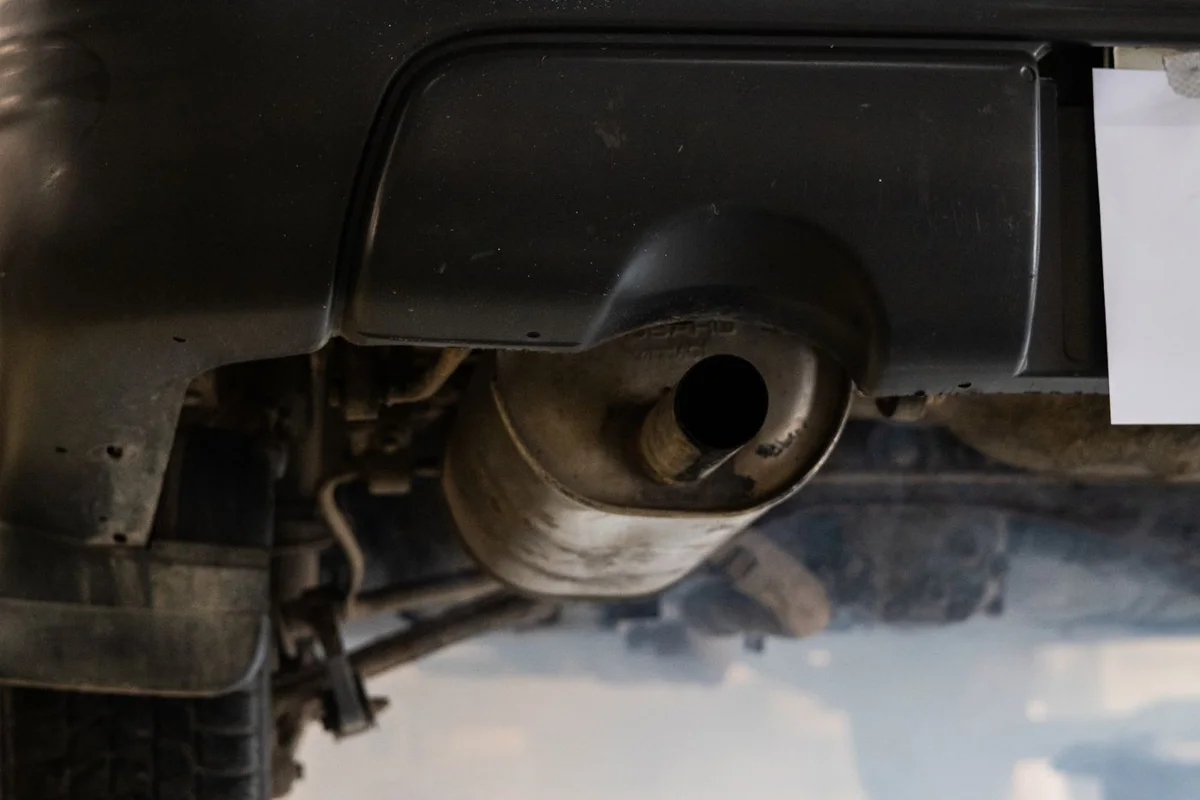 Exhaust vapour emerging below a car’s rear bumper