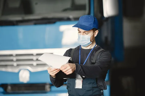 Employé d'atelier examinant les documents d'un véhicule