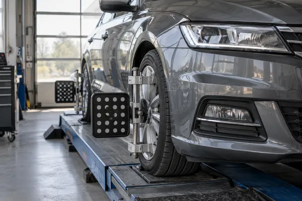 Des appareils de mesure de géométrie installés sur les roues d’une voiture.