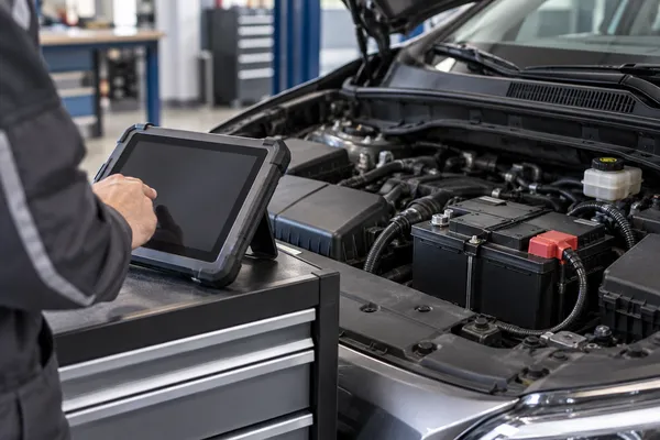 Une tablette de diagnostic à côté d’une batterie récemment installée