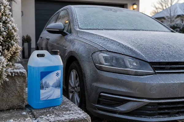 Du lave-glace préparé près d’une voiture un matin de gel