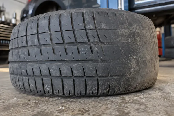 Une usure irrégulière sur l’épaule d’un pneu de voiture.