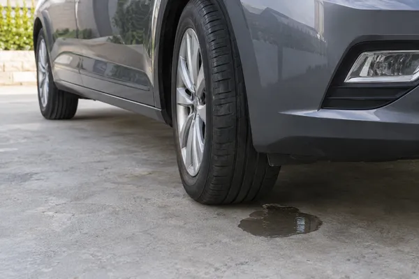 Petite flaque sous une voiture stationnée