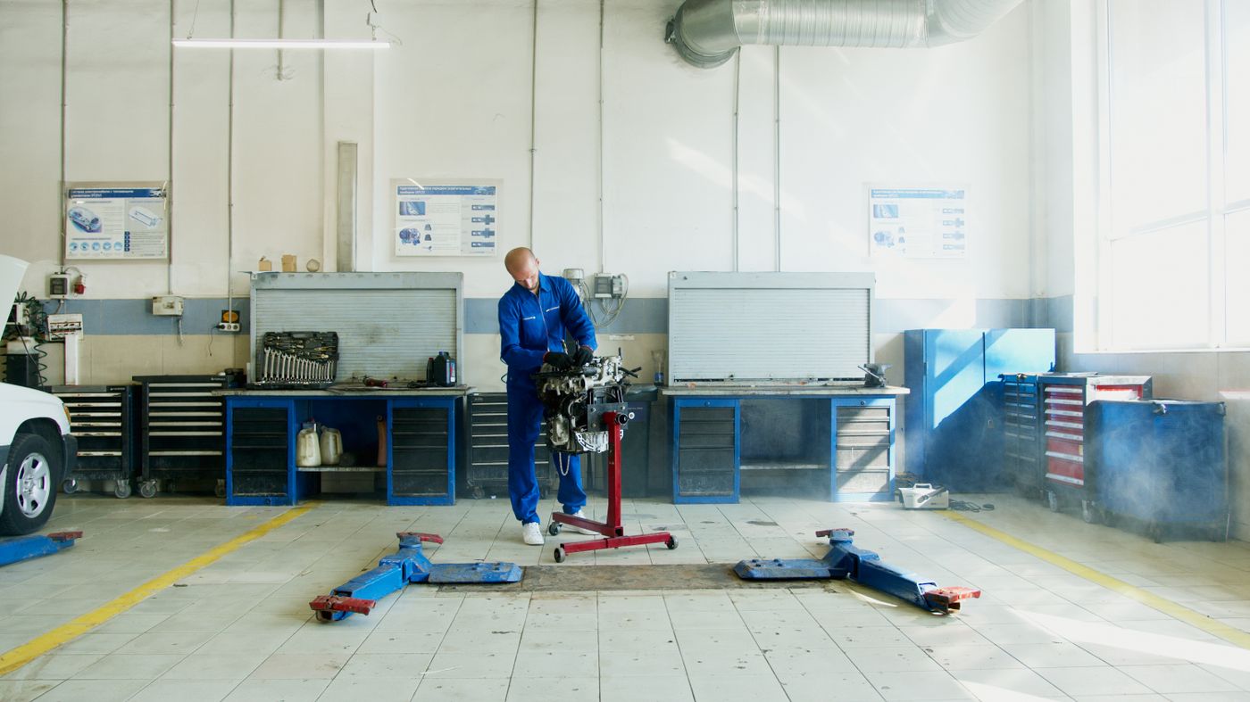 Un mécanicien examine un moteur sur un support d’atelier